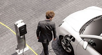 man-looking-back-at-his-white-electric-vehicle-car