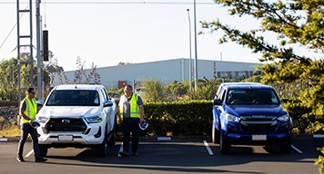 two-manufacture-guys-standing-next-to-car-outdoor