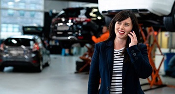 woman-smiling-talking-on-phone-car-repair-shop