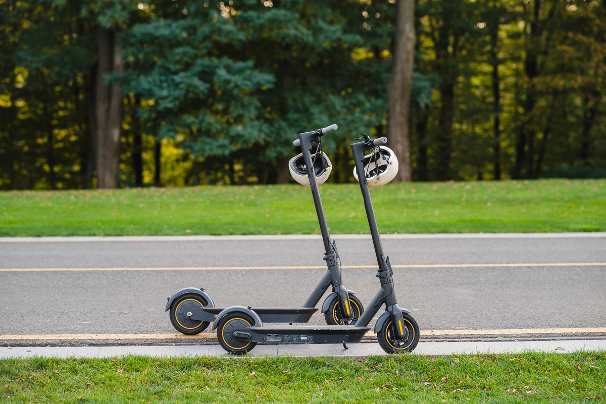 Two scooters with helmets on the footpath
