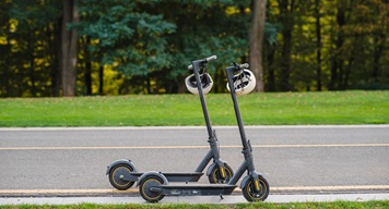 Two scooters with helmets on the footpath