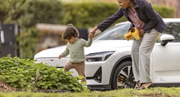 Woman with small child walking alongside the road
