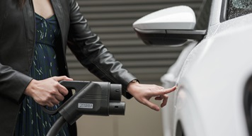 Woman plugging in EV charging cable