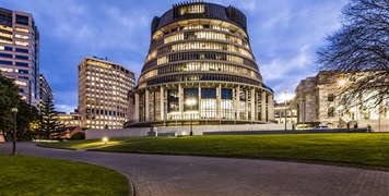 The Beehive building in Wellington, New Zealand, illuminated at dusk—symbolising government partnerships in sustainable fleet management and vehicle leasing services.