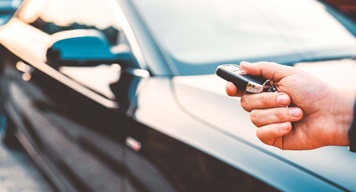 Car key in focus with car behind