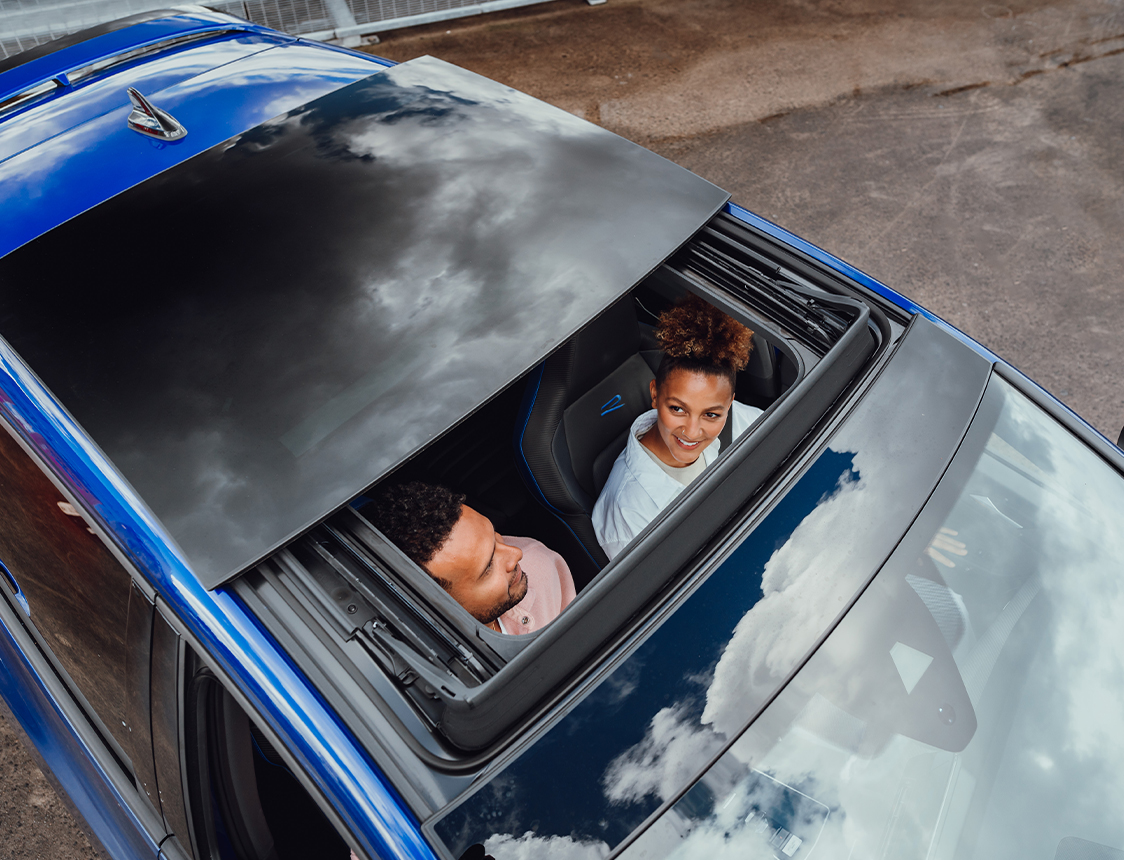 Two people in a car, as seen from above through a sun roof