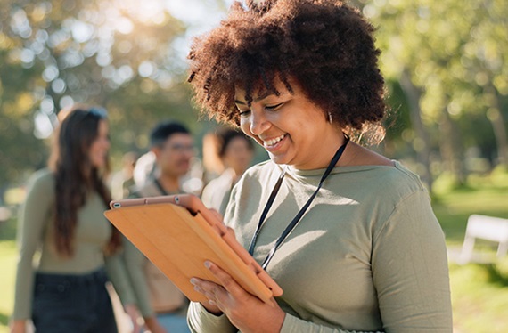 woman-smiling-at-tablet-outdoors