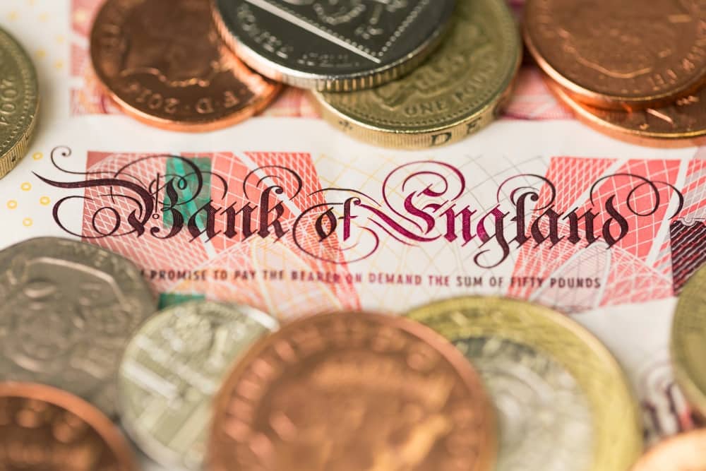 Close-up of Bank of England note with British coins