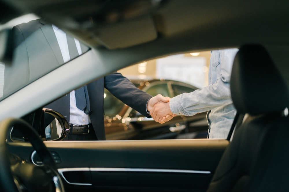 People shake hands to make a company car deal