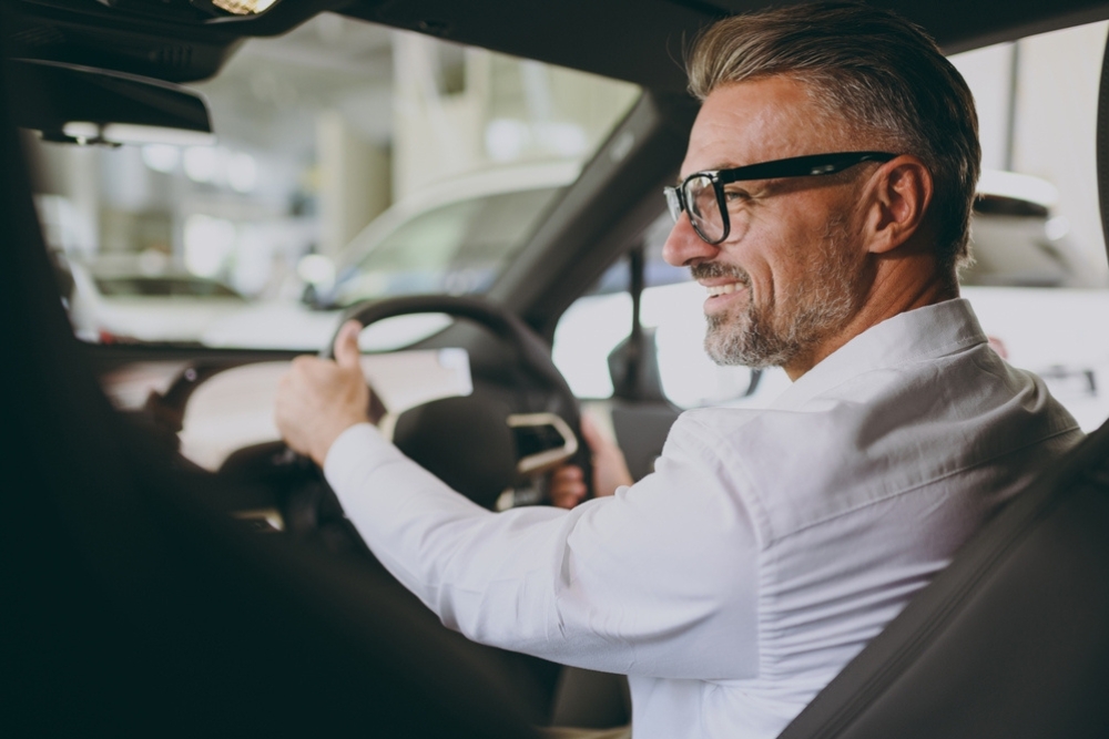 A happy man drives his company car
