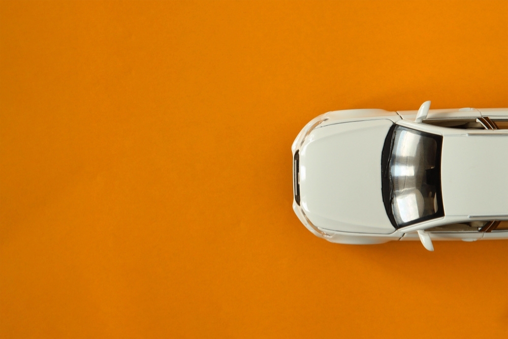 A car driving across an orange background, top down view