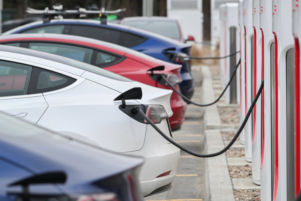 Rows of electric cars plugged into charge points, illustrating ECOS Changes and how UK salary sacrifice car schemes support a shift to cleaner vehicles.