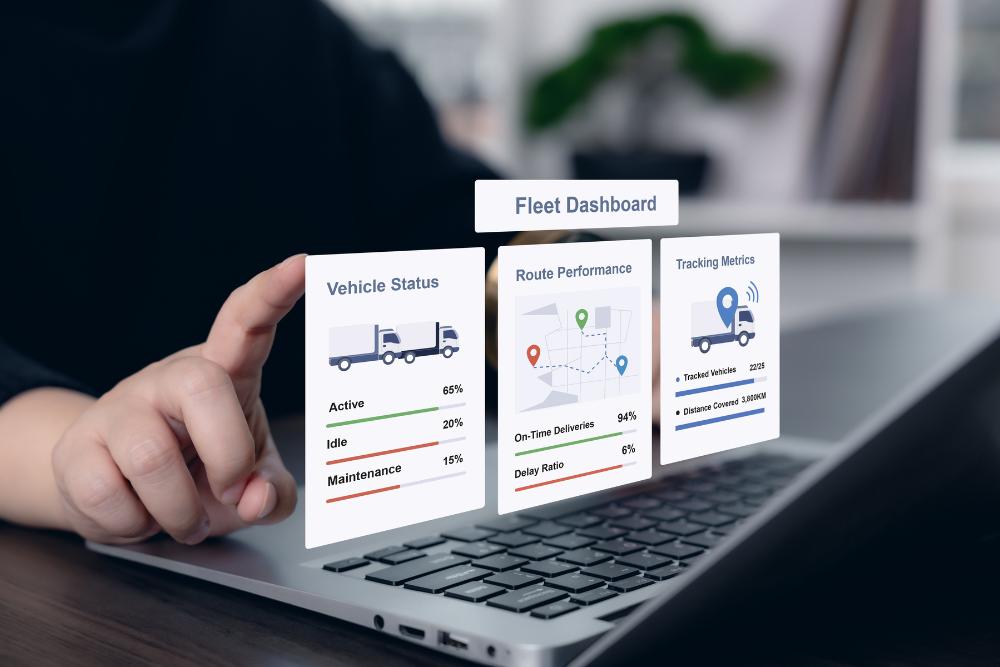 How do I manage fleet vehicles during summer holiday staff absences: A person using a laptop with a floating digital fleet dashboard showing vehicle status, route performance and tracking metrics, including delivery vans and percentages.