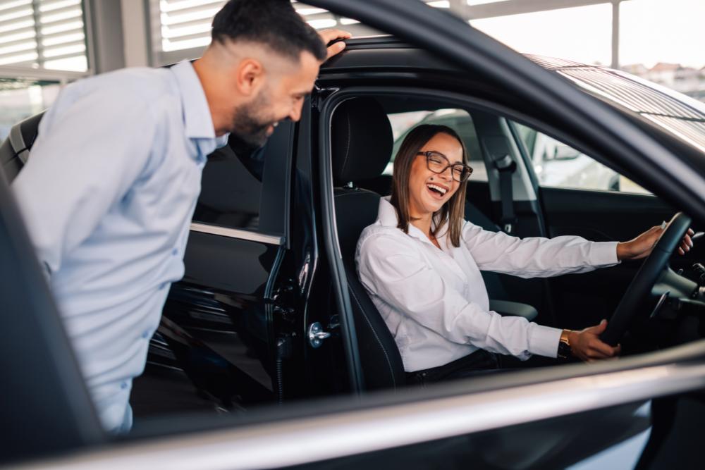 Staff car scheme Employee sitting in a new car while speaking with a representative, illustrating a staff car scheme in action