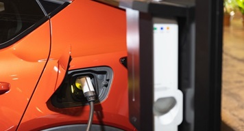 image of orange electric car being charged